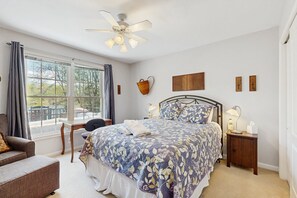 A bedroom with a bed, a chair, a desk, a window, and a ceiling fan. - Tranquil Lakefront Retreat With hot Tub, Screened Porch, Kayaks, and More (Bumpass)