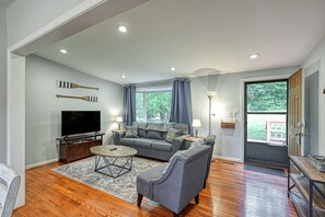 A living room with a sofa, TV, coffee table, and lamps. - Quiet Lake Home With two Kayaks, Furnished Deck, Grill & Fast Wifi - Dogs OK (Mineral)