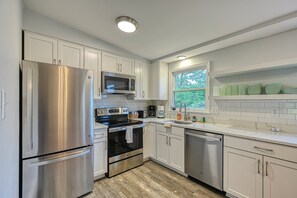 A modern kitchen with white cabinets, stainless steel appliances, a window with a view, and a countertop with dishware. - Quiet Lake Home With two Kayaks, Furnished Deck, Grill & Fast Wifi - Dogs OK (Mineral)