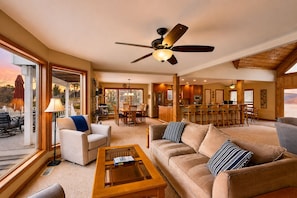 A spacious living area with a ceiling fan, a dining area, and a kitchen. - Lakefront Retreat With Views, hot Tub, Kid's Play Area, Dock & Fiber Internet (Mineral)