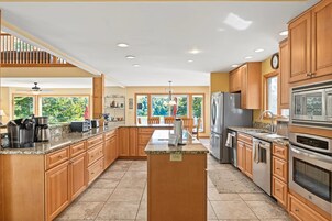 A spacious kitchen with wooden cabinets, granite countertops, and stainless steel appliances.