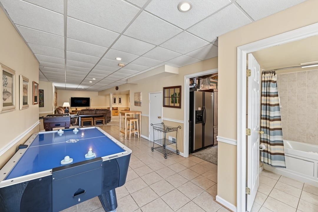 A spacious living area with a foosball table, a kitchen area, and a bathroom with a shower curtain.