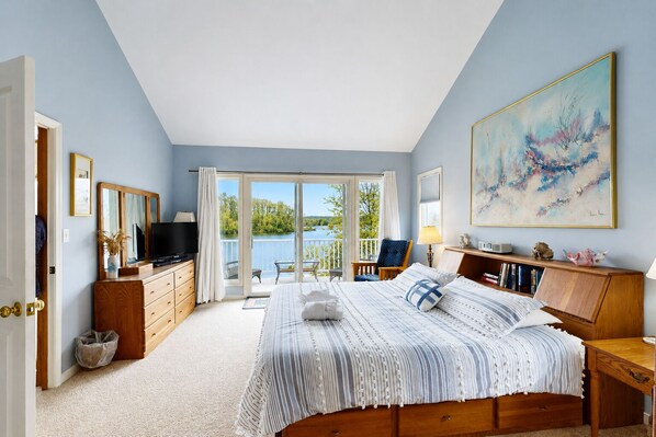 A bedroom with a bed, a TV, a desk, a chair, and a painting. - Lakefront Retreat With Views, hot Tub, Kid's Play Area, Dock & Fiber Internet (Mineral)