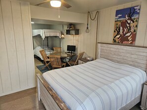 A bedroom with a bed, a desk, a chair, and a painting on the wall. - Relaxing 5-bedroom house with one of the best views at Lake Mac. (Brule)