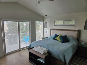 A bedroom with a bed, a bench, a nightstand, a ceiling fan, and a window with blinds. - Relaxing 5-bedroom house with one of the best views at Lake Mac. (Brule)