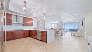 Una cocina moderna con una isla central, armarios de madera y lavavajillas.