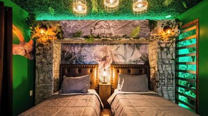 A room with a bed, a 'Jurassic Park' themed wall, and green ambient lighting. - Disney Dream Home | Mario, Frozen & Minions (Davenport)