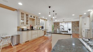 A kitchen with wooden cabinets, a granite countertop, and a built-in stove. - Apartment at S Front St Philadelphia (Philadelphia)