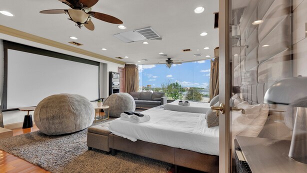 A modern bedroom with a large bed, a sofa, and a ceiling fan. - Apartment at S Front St Philadelphia (Philadelphia)