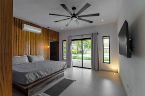 A bedroom with a bed, ceiling fan, and large windows. - 4 bedrooms Hacienda style home in Las Golondrinas, Hacienda Pinilla near beach (Tamarindo)