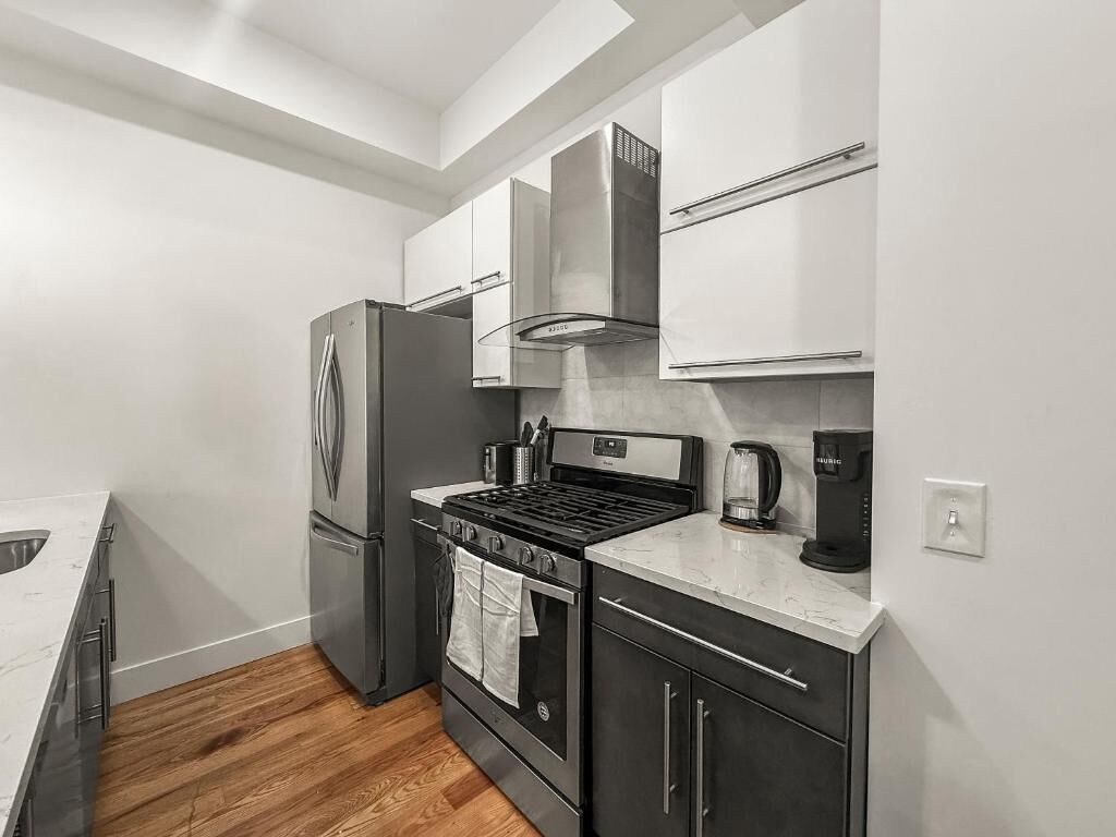 Una cocina compacta con refrigerador, estufa, horno y microondas.