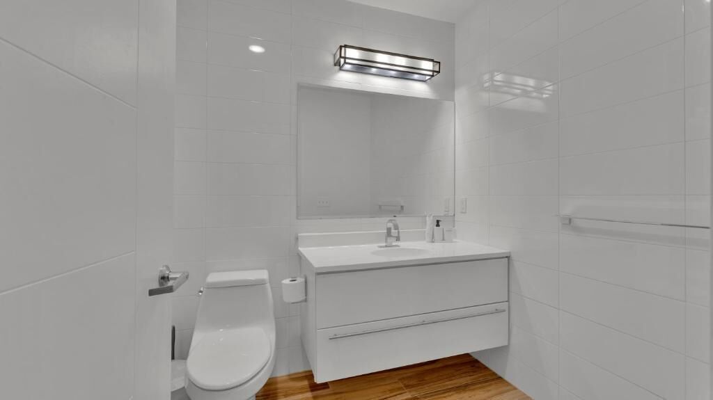 Ein modernes Badezimmer mit Toilette, Waschbecken und Spiegel.