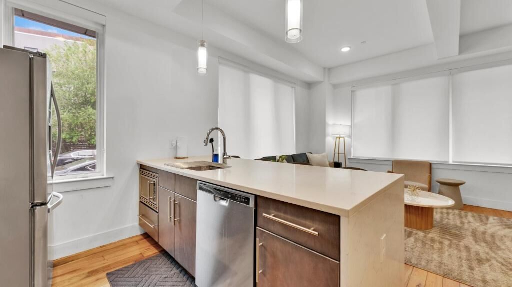 A modern kitchen with a dishwasher, a sink, and a large island.