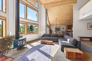 Ein geräumiges Wohnzimmer mit einer großen Couch, einem Kamin und einer Steinwand.