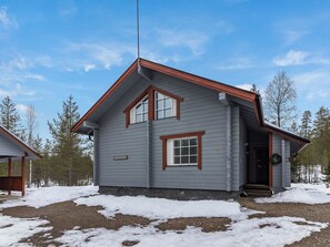 A two-story house with a grey exterior and red trim, a chimney, and a number '12' sign. - Luonnonrauha a by Interhome (Sodankylä)