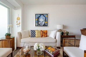 A living room with a sofa, coffee table, and a painting on the wall. - Luxury apartment Nuevo Vallarta Villa Magna condo (Nuevo Vallarta)