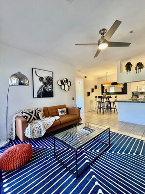 Ein Wohnzimmer mit einer Couch, einem Couchtisch und einem gemusterten Teppich.