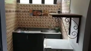 Una cucina compatta con lavandino, fornello e frigorifero.