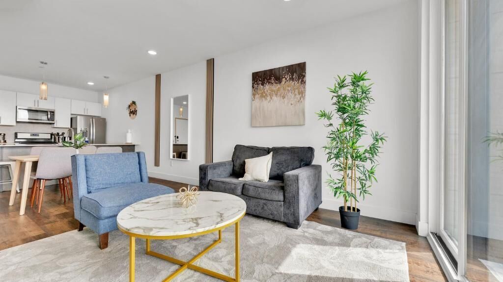 Uma sala de estar moderna com um sofá, uma mesa de centro e um vaso de planta.