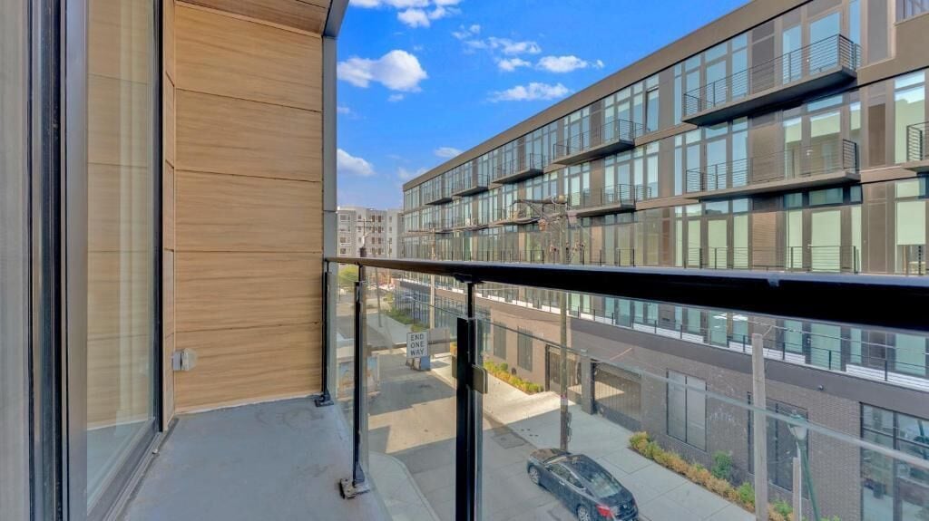 Un bâtiment moderne doté de grandes fenêtres et d’un balcon.