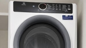 Una lavadora y secadora apiladas, con paneles de control y logotipos de marca.