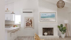 A modern kitchen with white brick walls, a white countertop, and bar stools.
