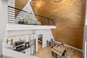 Eine moderne Loft-Wohnung mit Küche, Essbereich und Schlafgalerie mit Balkon.
