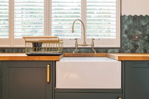 A kitchen with a sink, wooden countertop, and a window with blinds. - Renovated Spacious 3-Bed Newark Home with High Ceilings (Newark-on-Trent)