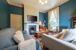 A living room with a fireplace, television, and comfortable seating. - Renovated Spacious 3-Bed Newark Home with High Ceilings (Newark-on-Trent)