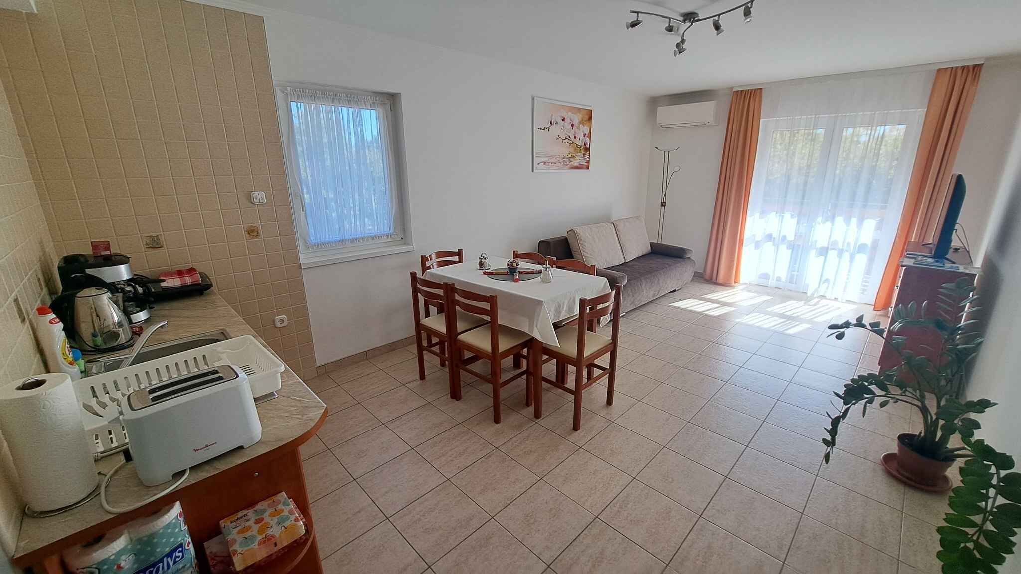 A compact living space with a dining area, kitchenette, and a sofa.