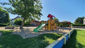 A playground with a slide and climbing structures. - Holiday apartment with Wi-Fi, air conditioning, balcony and parking (Zamárdi)