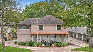 A two-story residential building with a front entrance, a small porch, and a mailbox. - 1 BD Near Ochsner | Quiet Courtyard Community (Jefferson)