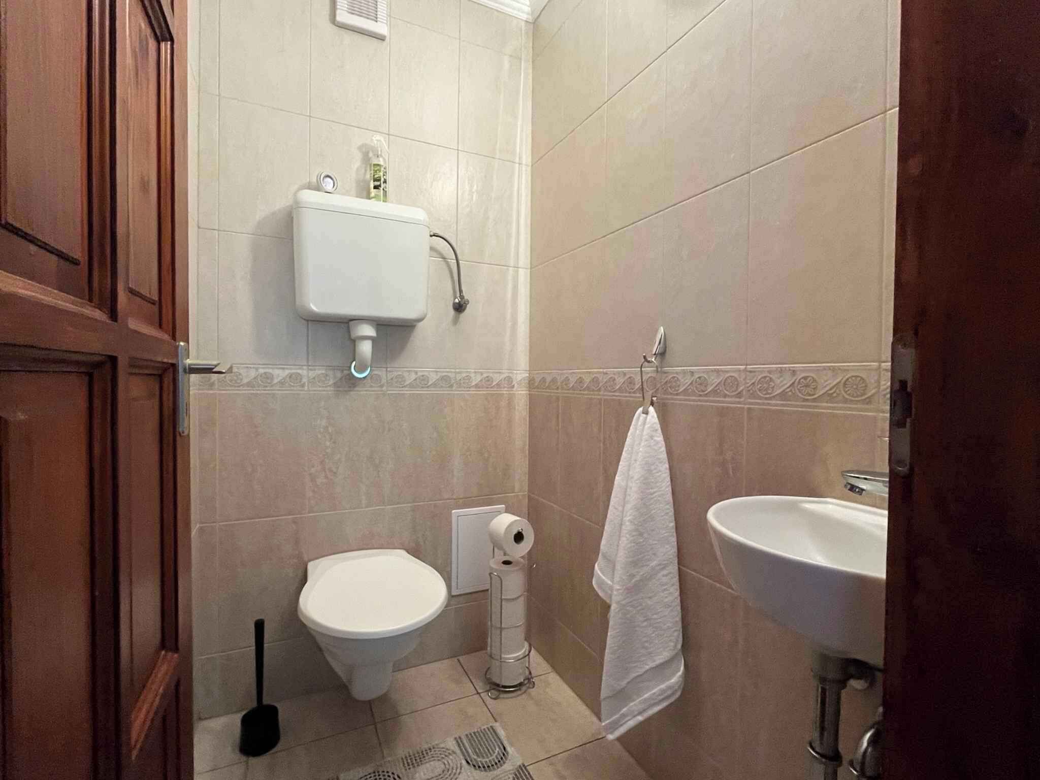Un baño con inodoro, bidé, lavabo y una toalla colgada en la pared.