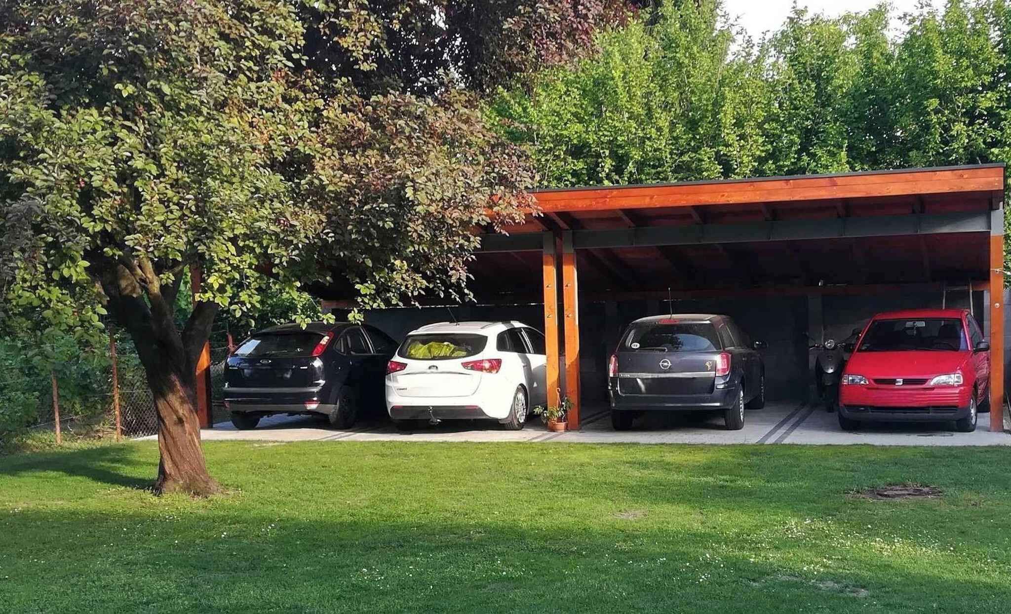 A covered parking area with four cars parked under a roof.