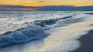 A beach with waves and a sunset. - Spacious Gulf Shores Beach House With Pool Access and Ocean Views (Gulf Shores)