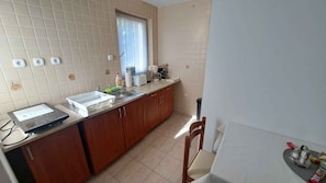 A kitchen with a countertop, sink, cabinets, and a window. - Ground-floor holiday apartment with terrace, Wi-Fi, air conditioning and parking (Zamárdi)