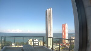 Un balcó amb vista al mar i edificis alts.