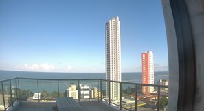 En balkon med havudsigt og høje bygninger.
