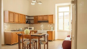 Una cocina con armarios de madera, un salpicadero de azulejos, una isla central con sillas, una estufa y un ventanal.
