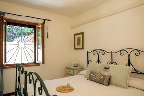 A bedroom with a bed, a window with a view, a bedside table, and a picture on the wall. - The Port of Dreams - Porto Rotondo (Porto Rotondo)