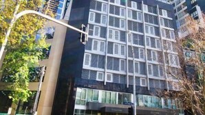 Un edificio moderno con fachada de entramado, amplias ventanas y una entrada destacada.