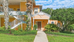 A two-story building with a central entrance, a staircase on the left, and a small porch area. - Family-Friendly Retreat Near Disney (Davenport)