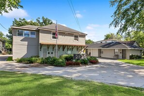 A two-story building with a flag, a sign with the number 2537, and a small attached structure. - Arlington Rentals Unit 3b (Studio) (Jefferson)