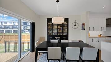 Una cocina moderna con comedor, ventanas amplias y vista a una zona residencial.