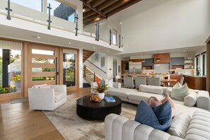 Ein geräumiger Wohnbereich mit Sofa, Couchtisch und einer Treppe zu einer oberen Ebene.
