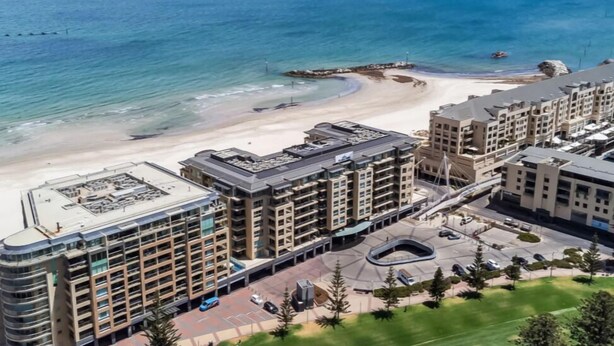 A coastal hotel with multiple floors, a beach view, and a parking area. - Park View Hideaway (Glenelg)