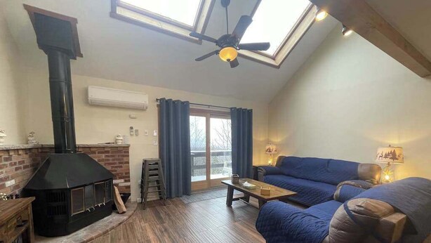 Una sala de estar acogedora con chimenea, un sofá, una mesa de centro y un tragaluz.