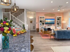 Open-concept interior view featuring staircase, gourmet kitchen, spacious living room, and elegant coastal design throughout the home. - 2nd Row Beach | Hot Tub & Game Room | Sleeps 16 (Galveston)