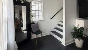 A modern interior with a staircase, a chair, a potted plant, and a flat-screen TV. - Lovely 2-bedroom house in vibrant Downtown Atlanta (Atlanta)