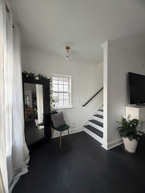 A modern interior with a staircase, a chair, a potted plant, and a flat-screen TV. - Lovely 2-bedroom house in vibrant Downtown Atlanta (Atlanta)